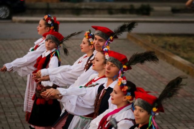 Tancerze w polskich strojach ludowych stojący w rzędzie podczas tańca Polonez