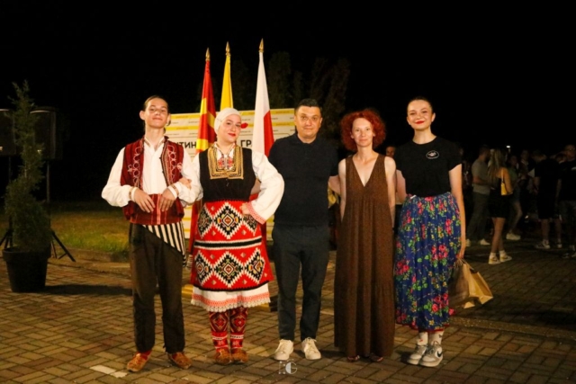 Para macedońskich tancerzy, mężczyzna, kobieta i tancerka w polskim stroju ludowym pozują do zdjęcia