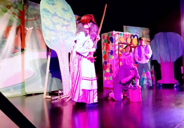 Na scenie czworo aktorów Jaś, Małgosia, Baba Jaga i szczur. W tle dekoracja przedstawiająca las i domek czarownicy.