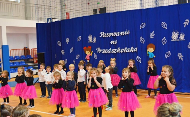 Dzieci z grupy "Wędrowniczki' w czasie swojego występu. W tle okolicznościowa dekoracja.