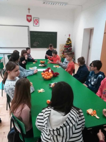 Spotkanie świąteczne klasy VI. Dzieci siedzą przy wspólnym stole.