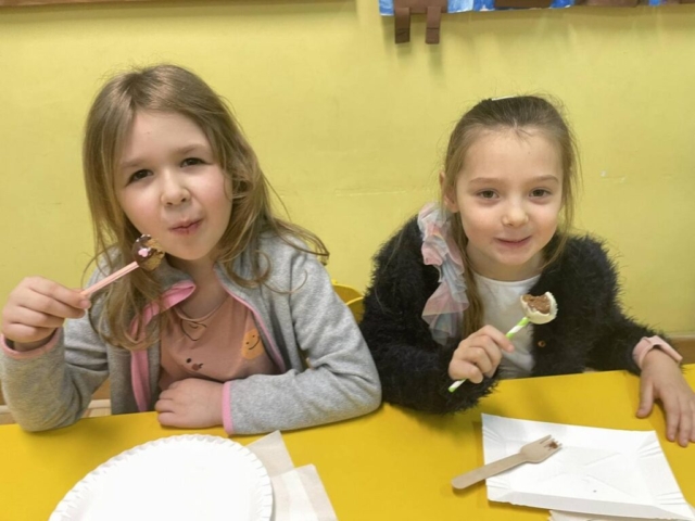 Spotkanie wigilijne klasy I - dziewczynki jedzą ciastka.