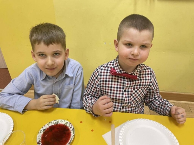 Spotkanie wigilijne klasy I - dwaj chłopcy przy świątecznym stole.