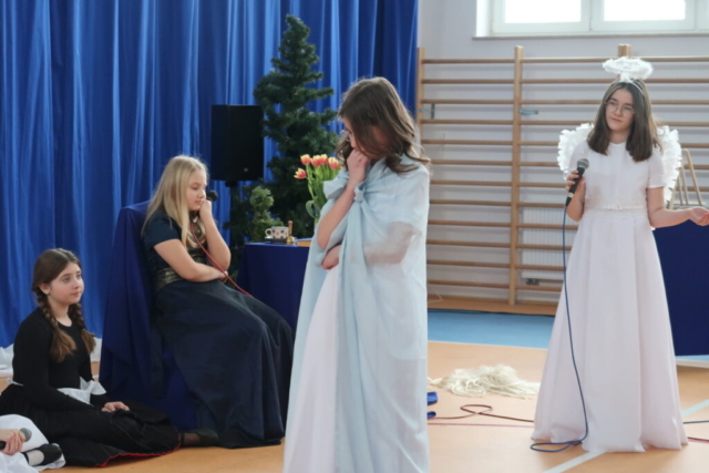 Cztery dziewczynki w rolach służącej, anioła, hrabiny i Maryi odgrywają scenkę biblijną nawiązującą do zwiastowania