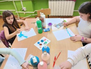 Dziewczynki z klasy 3 wykonują prace plastyczne z wykorzystaniem farb